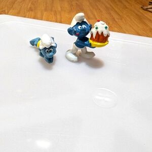 Peyo. Vintage Smurfs. One holding a Birthday Cake and one swimming.
